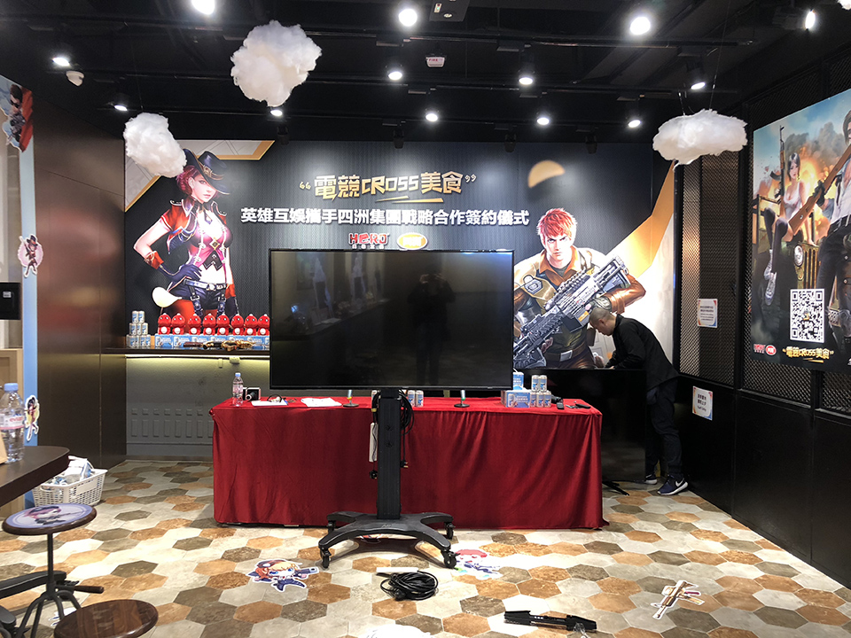 電競主題簽約儀式現場的大型電視及簽約桌